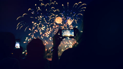 People are shooting fireworks display with their phones. Smartphone shooting