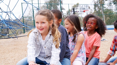 Elementary school kids spinning in a playground