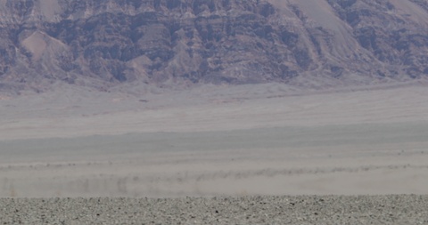 Close up of heat haze effect on desert floor. Mountains at background