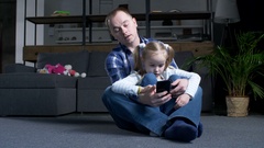 Resting dad and preteen girl networking on phone [133982519] | 写真素材・ストックフォトのアフロ