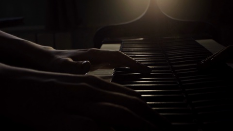 Woman pianist hands plays classical music on a grand piano close up in the sun