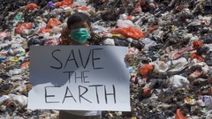 Boy showing a banner on the landfill [131649528] | 写真素材・ストックフォトのアフロ