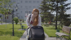 Young happy redhead mother walking with baby carriage and smiling … [133473951] | 写真素材・ストックフォトのアフロ