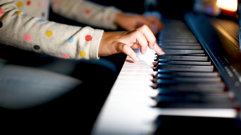 closeup kid's hand playing piano on stage, favorite classical music, hands of