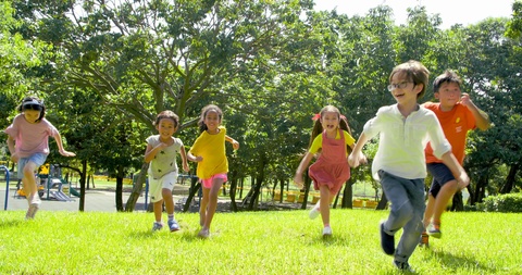 Multi-ethnic group of school children laughing and running