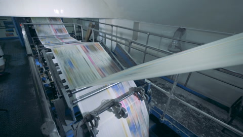 Colored newspaper pages printed in a typography room.