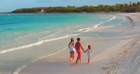 Family and Children Walk Together Along Tropical Beach