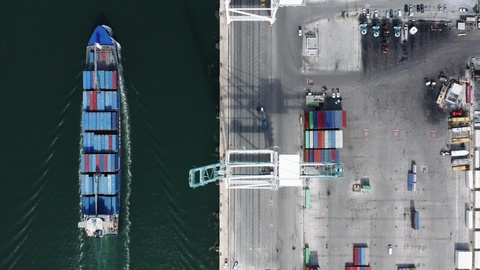 The wharf and the loaded cargo ship moving along it in Port Miami, USA