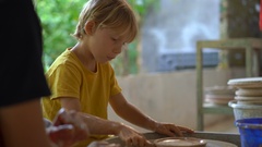 Closeup shot of a boy on a pottery master class [130773175] | 写真素材・ストックフォトのアフロ