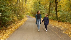 Woman with preteen girl holding hands and walking on the road … [130677722] | 写真素材・ストックフォトのアフロ