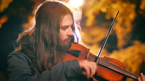 Street musician rock violinist playing classical wooden violin at night, autumn