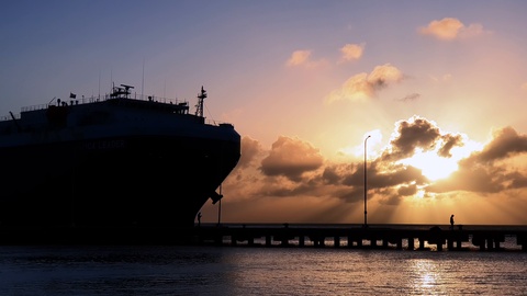 Silhouette of cargo ship for international trade approaching for docking