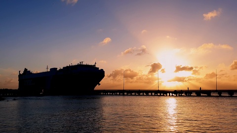 Silhouette of cargo ship for international trade approaching for docking