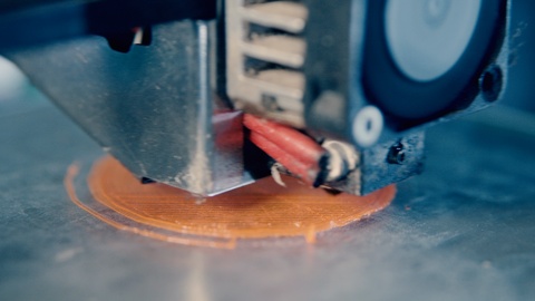 A 3D printer in works in a typography office.