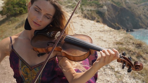 Young adult violinist woman playing beautiful and classical music on violin