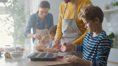 In Kitchen: Family of Four Cooking Muffins Together. Children Helping Parents