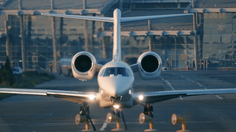 Business jet (private jet) is taxiing on the taxiway before taking off at sunset