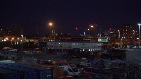 Night establishing shot of city skyline with warehouse business industrial park