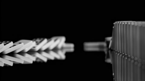 Domino effect: dominos falling in slow motion towards the camera, pan, 150fps