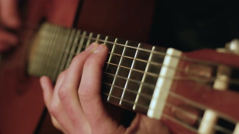 Man playing on the classical guitar with nylon strings.