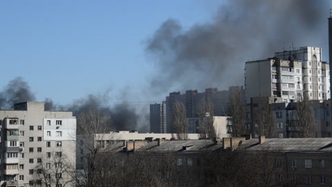 There is black smoke from a rocket or bomb explosion in a city during a war