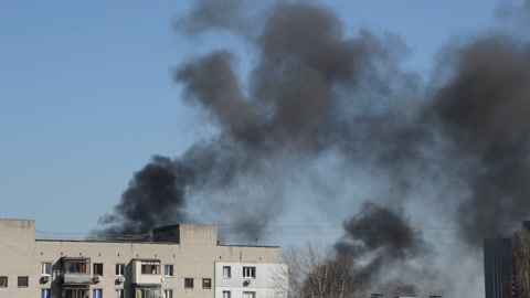 There is black smoke from a rocket or bomb explosion in a city during a war