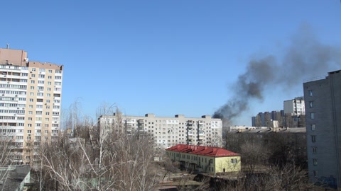 There is black smoke from a rocket or bomb explosion in a city during a war