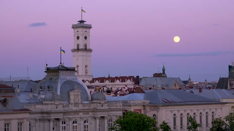 2022 - beautiful full moonrise over the rooftops and classical buildings in