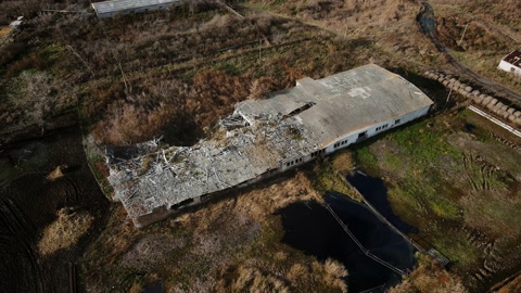 Aerial shot of the destroyed cattle barn and explosion crater, real war in