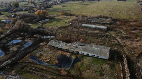 Aerial shot of the destroyed cattle barn and explosion crater, real war in