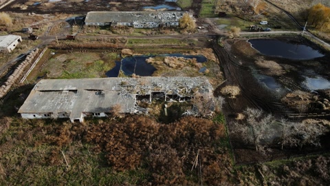 Aerial shot of the destroyed cattle barn and explosion crater, real war in