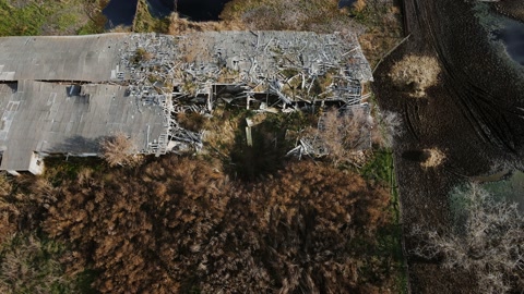 Aerial shot of the destroyed cattle barn and explosion crater, real war in