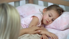 Mother sits next to daughter and puts sleep. Child laughs and … [207259440] | 写真素材・ストックフォトのアフロ