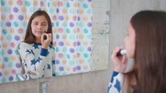 Preteen girl put on makeup by bathroom mirror. Realtime [212302521] | 写真素材・ストックフォトのアフロ 