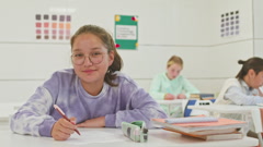 Portrait of Preteen Schoolgirl Writing Test in Class [220008186] | 写真素材・ストックフォトのアフロ