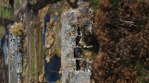 Vertical destroyed farm with explosion crater in real war in Ukraine