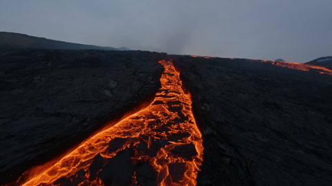 Aerial FPV view over molten magma crust, into the Volcanic crater mouth of