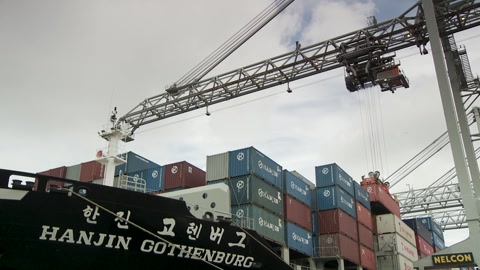 Red cargo container gets lifted to huge Hanjin Gothenburg vessel …の動画素材