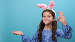 Preteen girl in bunny fluffy ears raises palm and showing okay … [243389548] | 写真素材・ストックフォトのアフロ