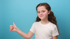 Portrait of preteen girl child standing with thumb up, showing … [243948035] | 写真素材・ストックフォトのアフロ 