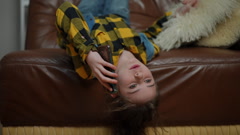 Cute preteen girl talking on a cell phone while lying upside … [244962834] | 写真素材・ストックフォトのアフロ