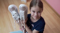 smiling teenage girl shows sneakers, bringing them to her face [246278259] | 写真素材・ストックフォトのアフロ