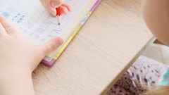 5-year-old girl diligently draws elements with pencil in notebook … [251911024] | 写真素材・ストックフォトのアフロ