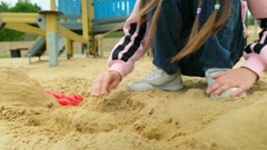 Close-up of little girl playing with molds in sand on the beach, … [257628106] | 写真素材・ストックフォトのアフロ